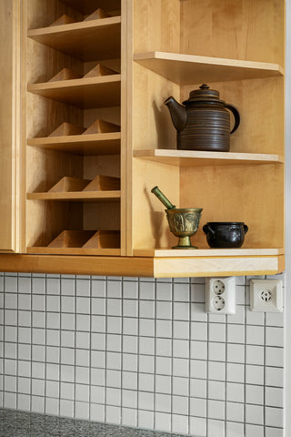 A kitchen cupboard with a teapot and a tea kettle