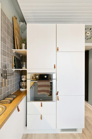 A kitchen with white cabinets and a sink