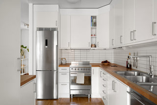 A kitchen with white cabinets and stainless steel appliances
